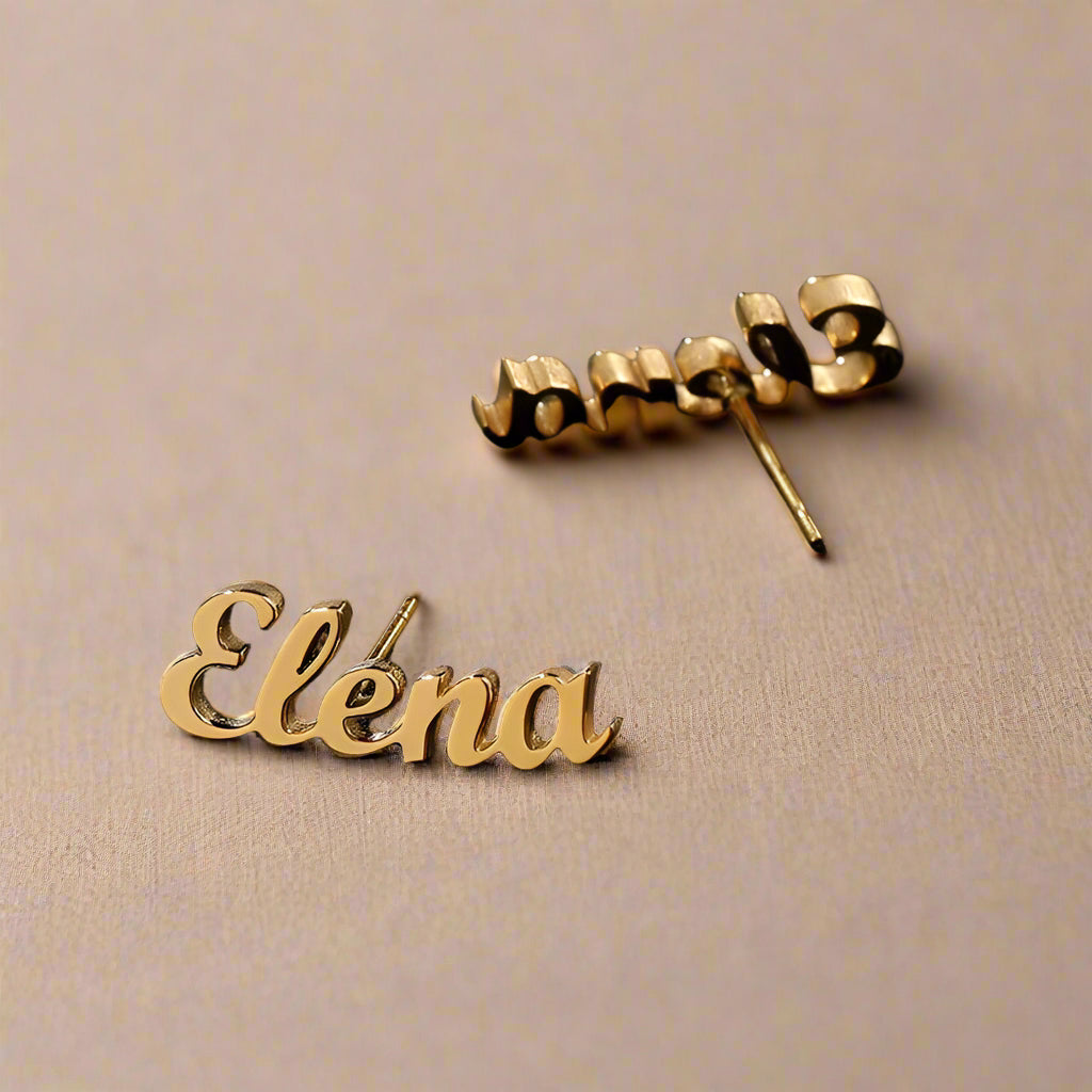 Minimalist gold script earrings displayed elegantly.