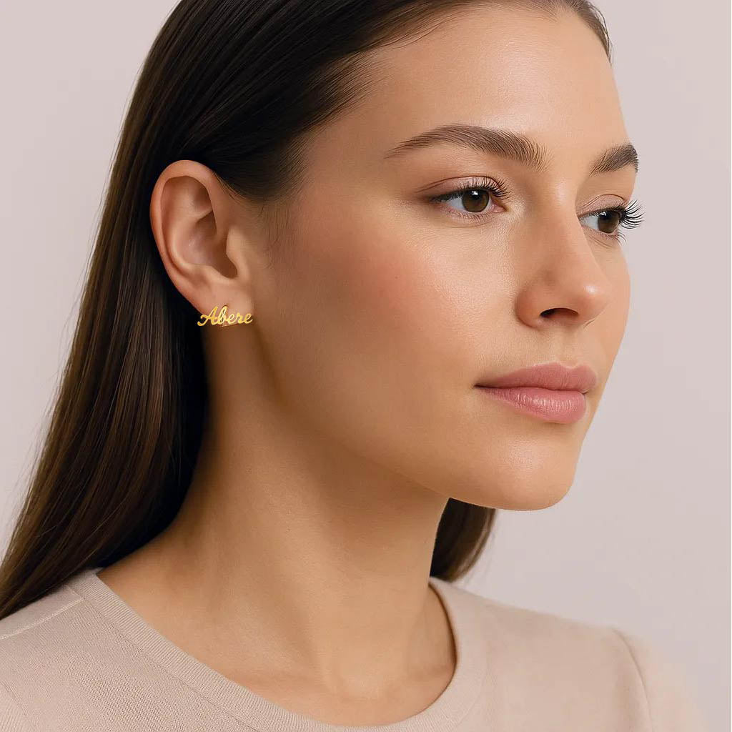 Minimalist gold script earrings displayed elegantly.
