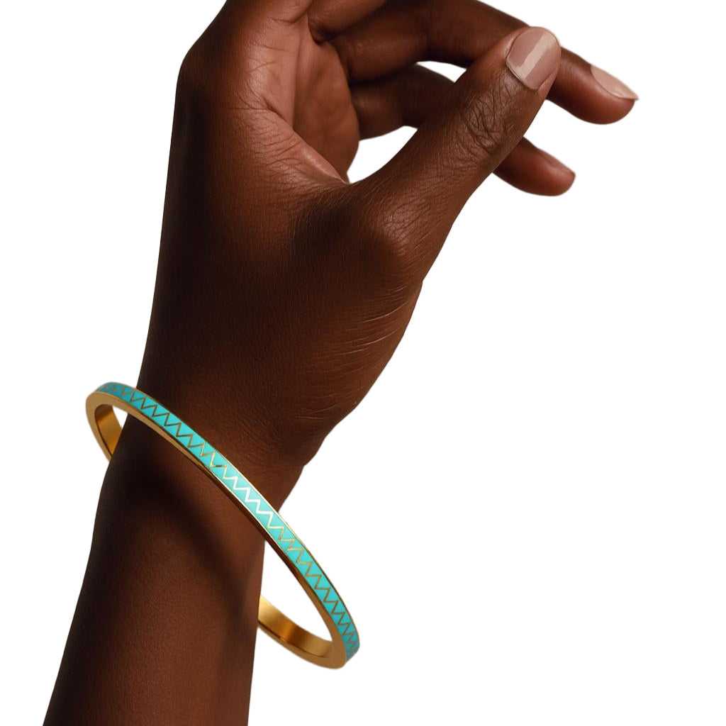 Hand wearing a turquoise bangle on a beige background