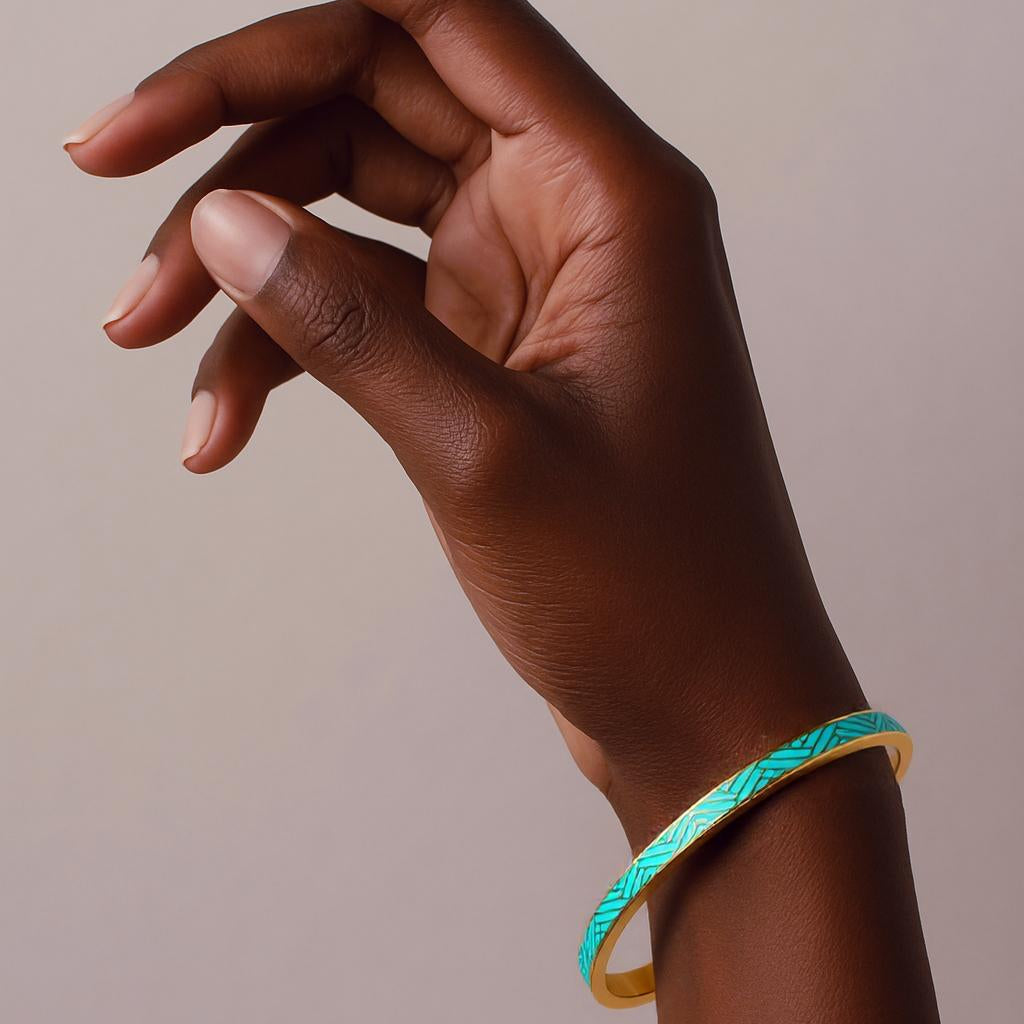 Hand wearing a turquoise bracelet on a beige background