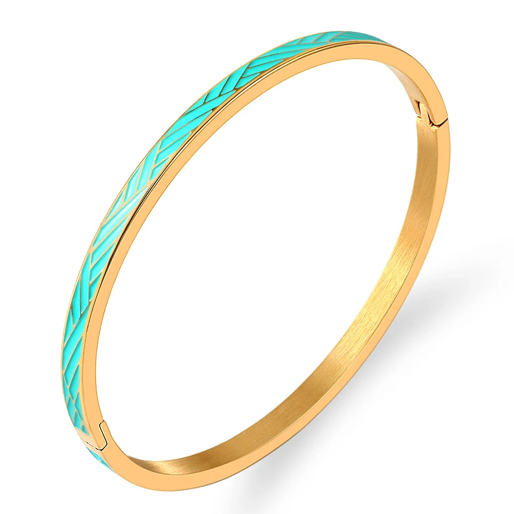 Gold bangle with turquoise pattern on a white background