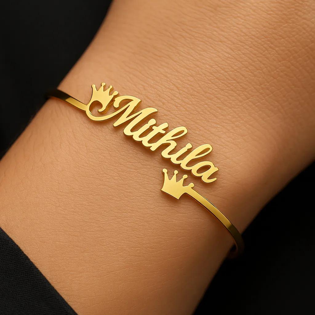 Gold bracelet with 'Mithila' on a wrist against a dark background