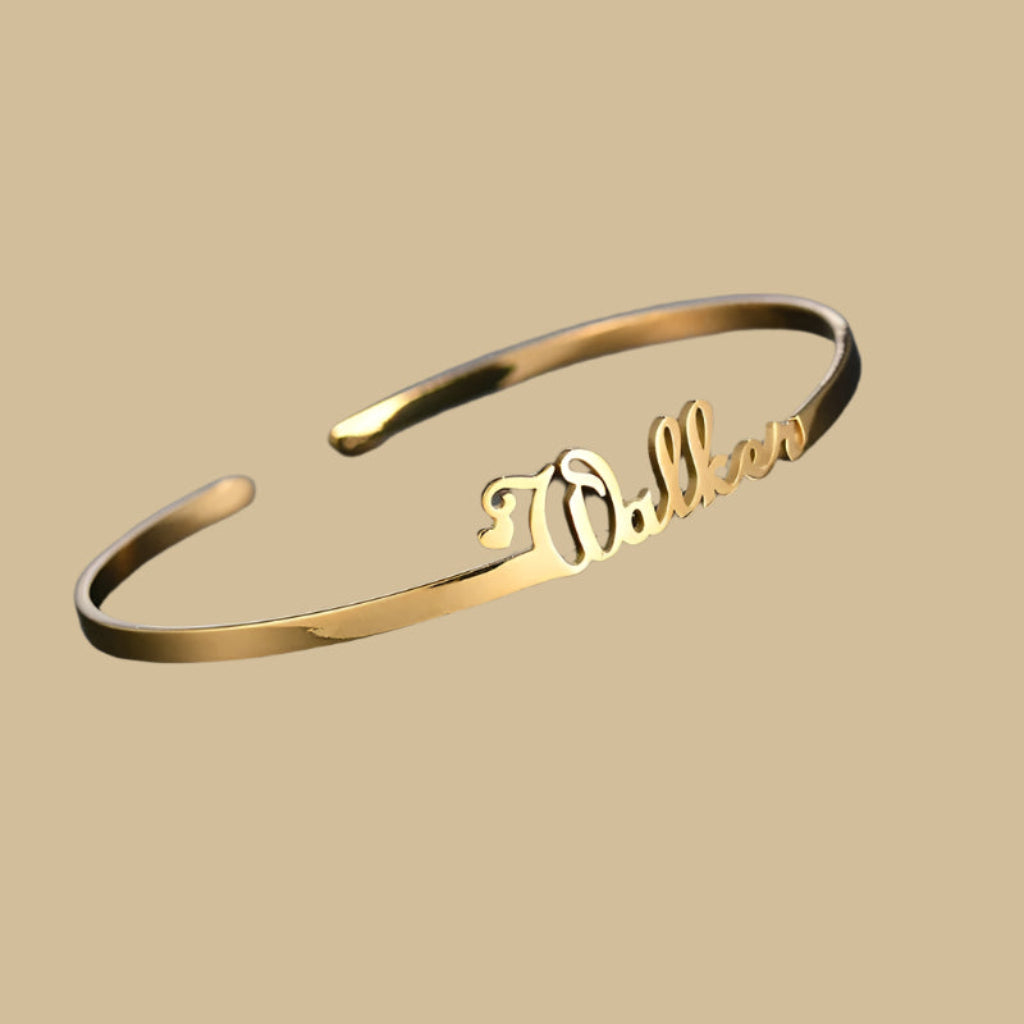 Gold bracelet with 'Dakota' engraving on a dark gray background