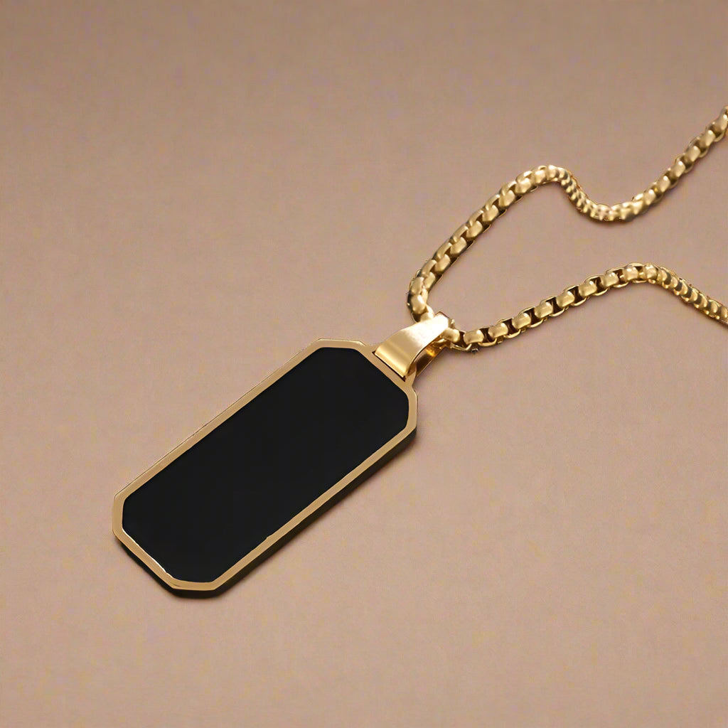 Close-up of men's silver stainless steel necklace with black enamel pendant