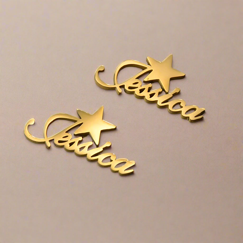 Close-up of gold earrings with personalized text and star.