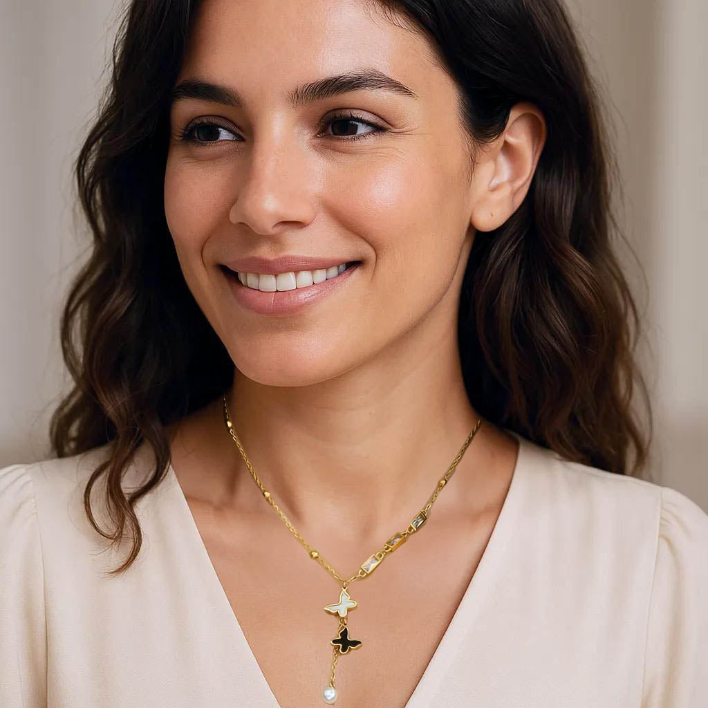 Gold butterfly necklace worn on model’s neck, showing delicate double charm