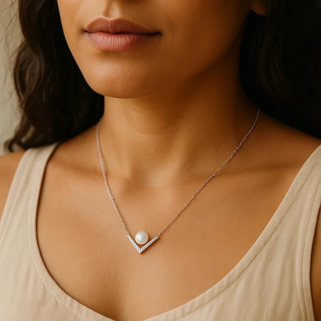 Close-up of a woman wearing a necklace with a pearl pendant.
