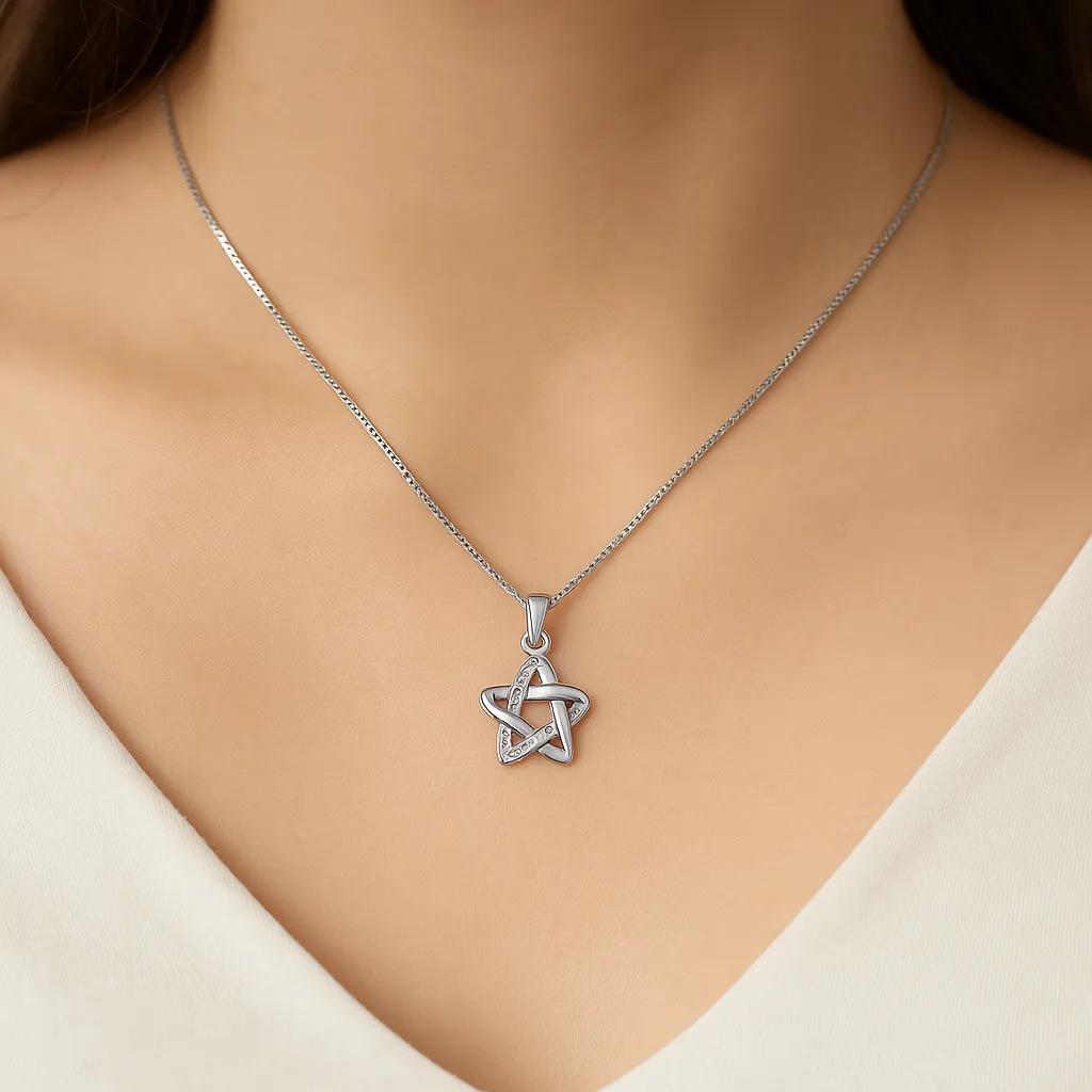 Silver star-shaped pendant necklace on a model wearing a white top
