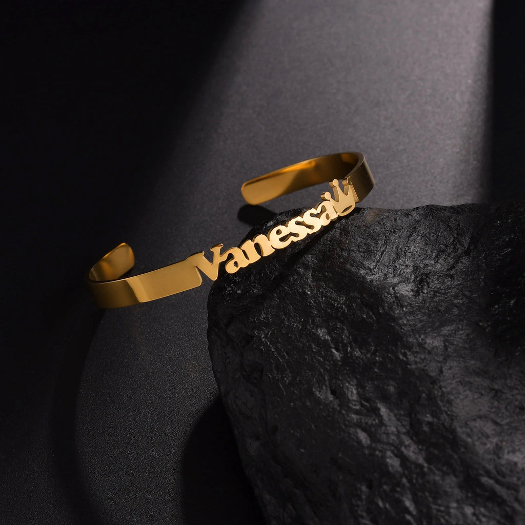 Gold bracelet with 'Vanessa' engraved on a dark stone surface