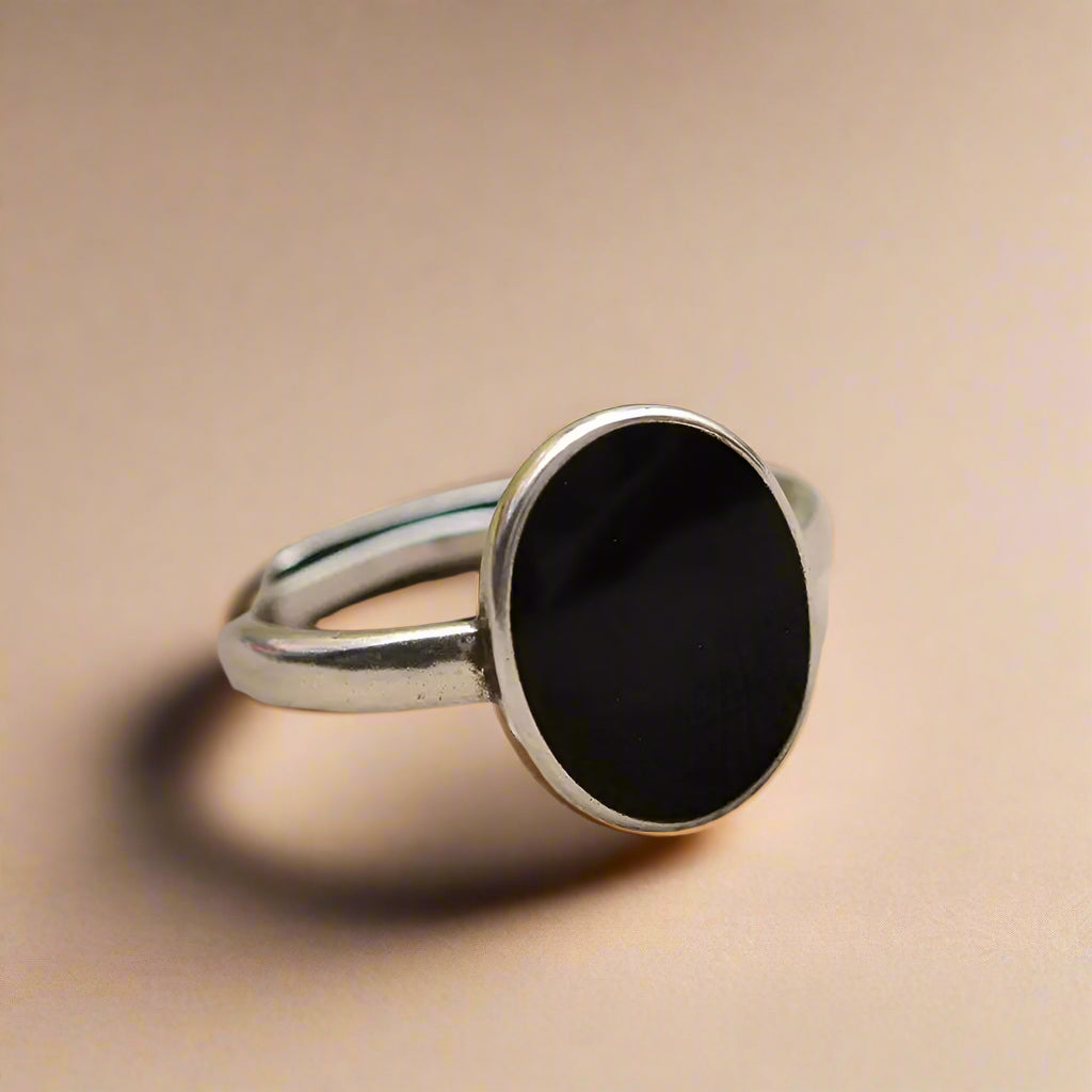Oval black resin ring on hand – sterling silver band