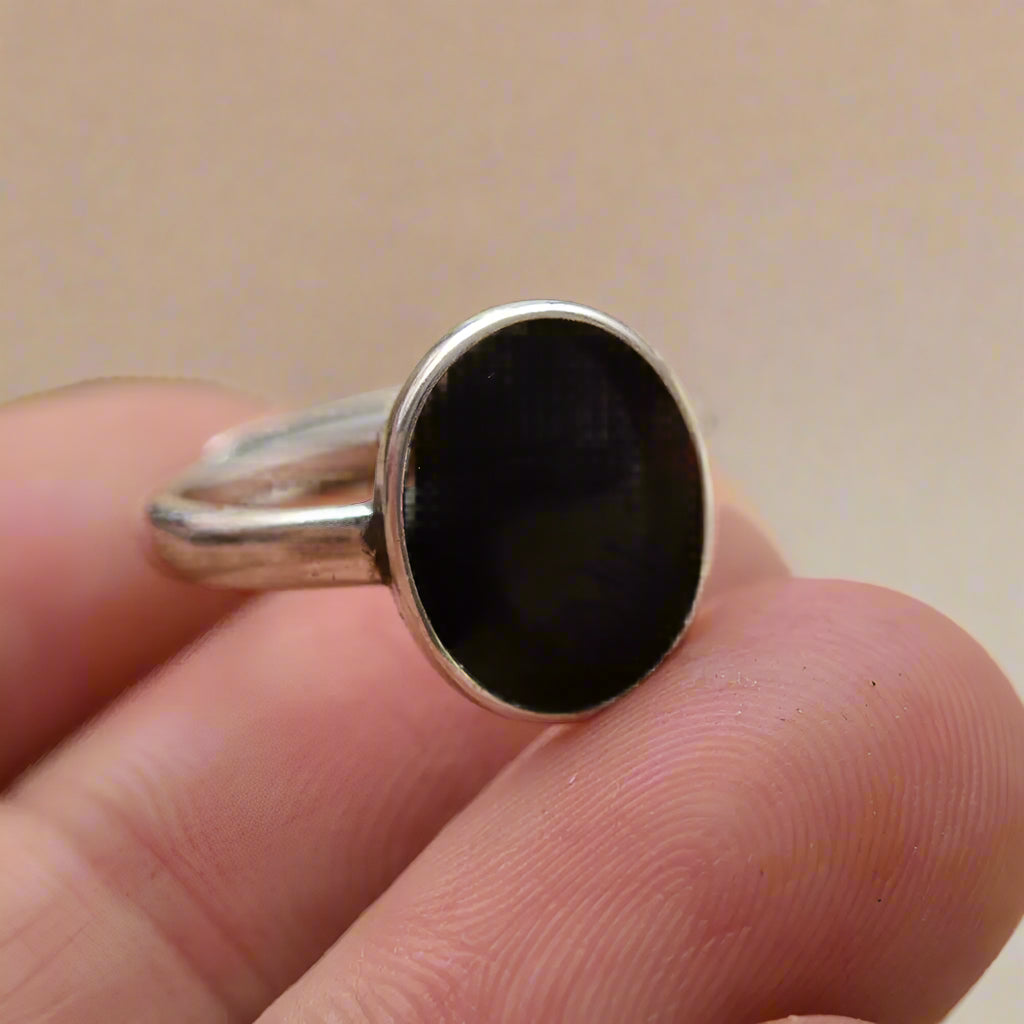 Oval black resin ring on hand – sterling silver band