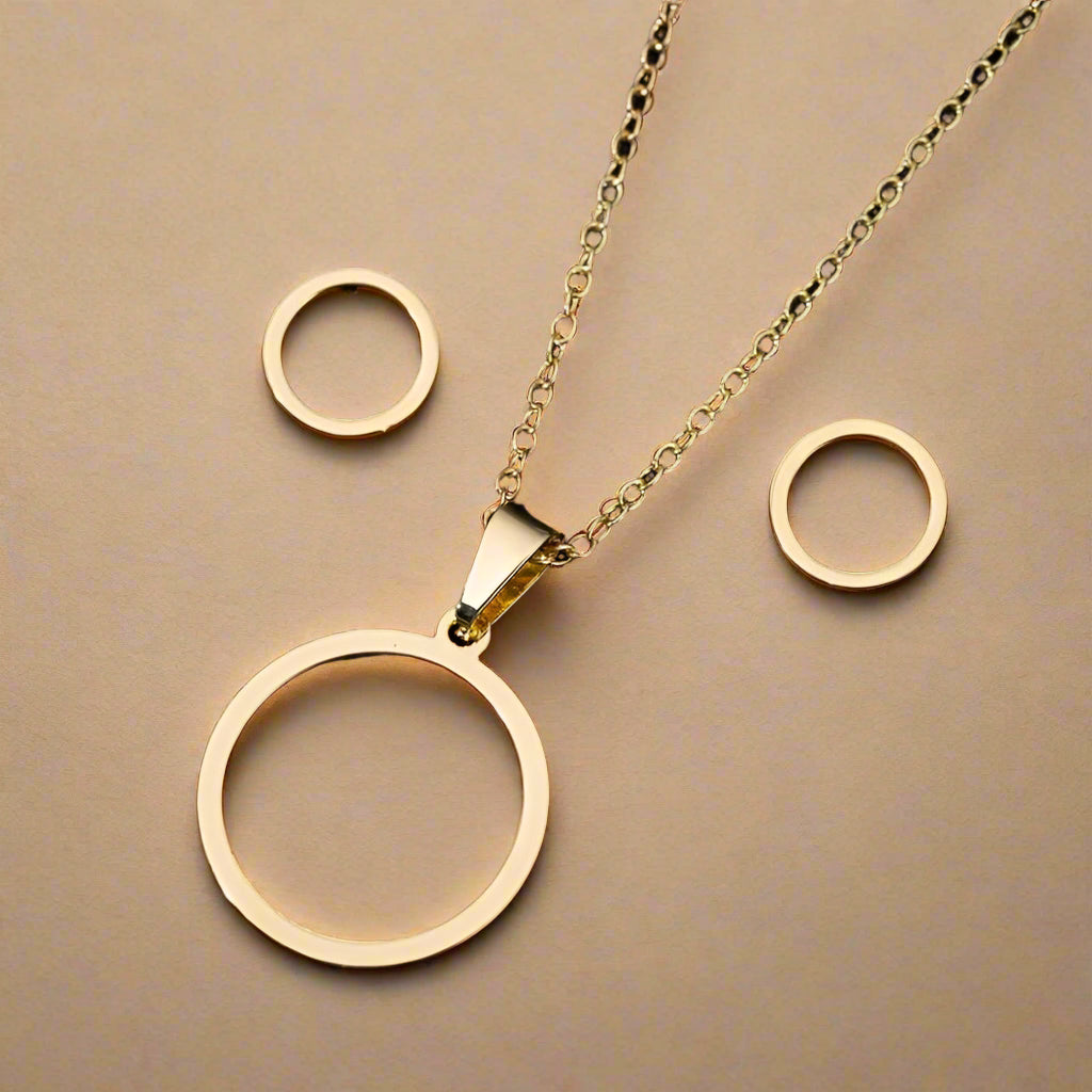 Gold stainless steel circle jewelry set on black background – necklace and stud earrings