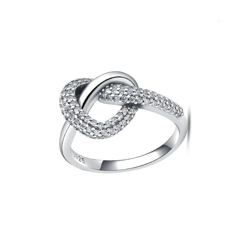 Silver ring with interlocking design on a white background