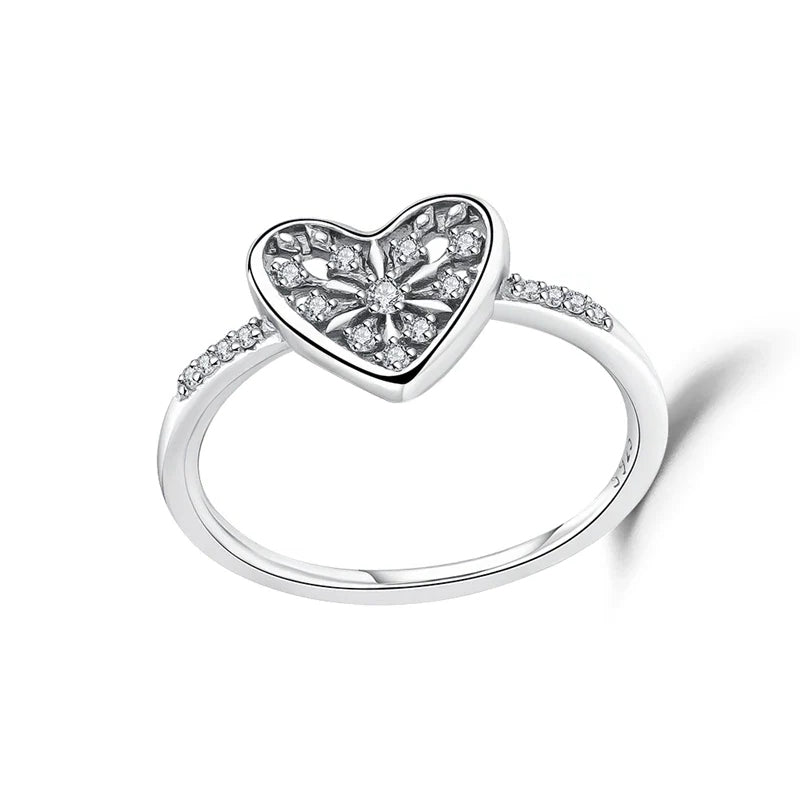 Silver heart-shaped ring with embedded stones on a white background