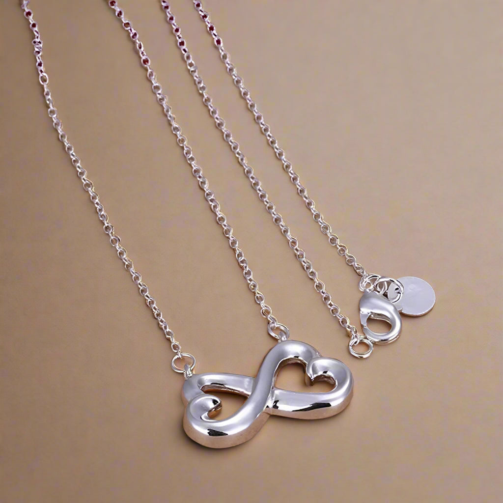Close-up of silver infinity-heart pendant with chain.  