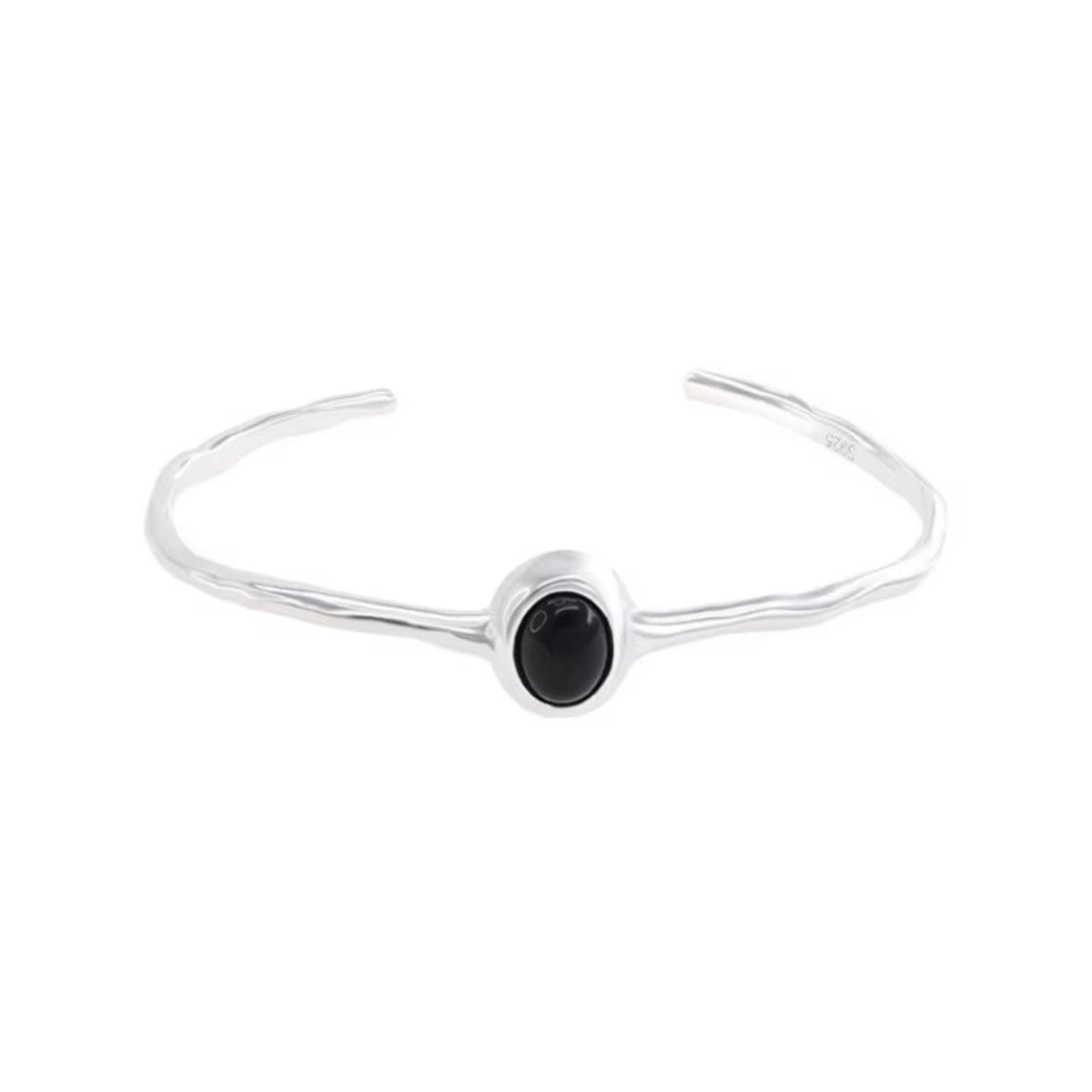 Minimalist silver bracelet with black oval stone on woman's wrist