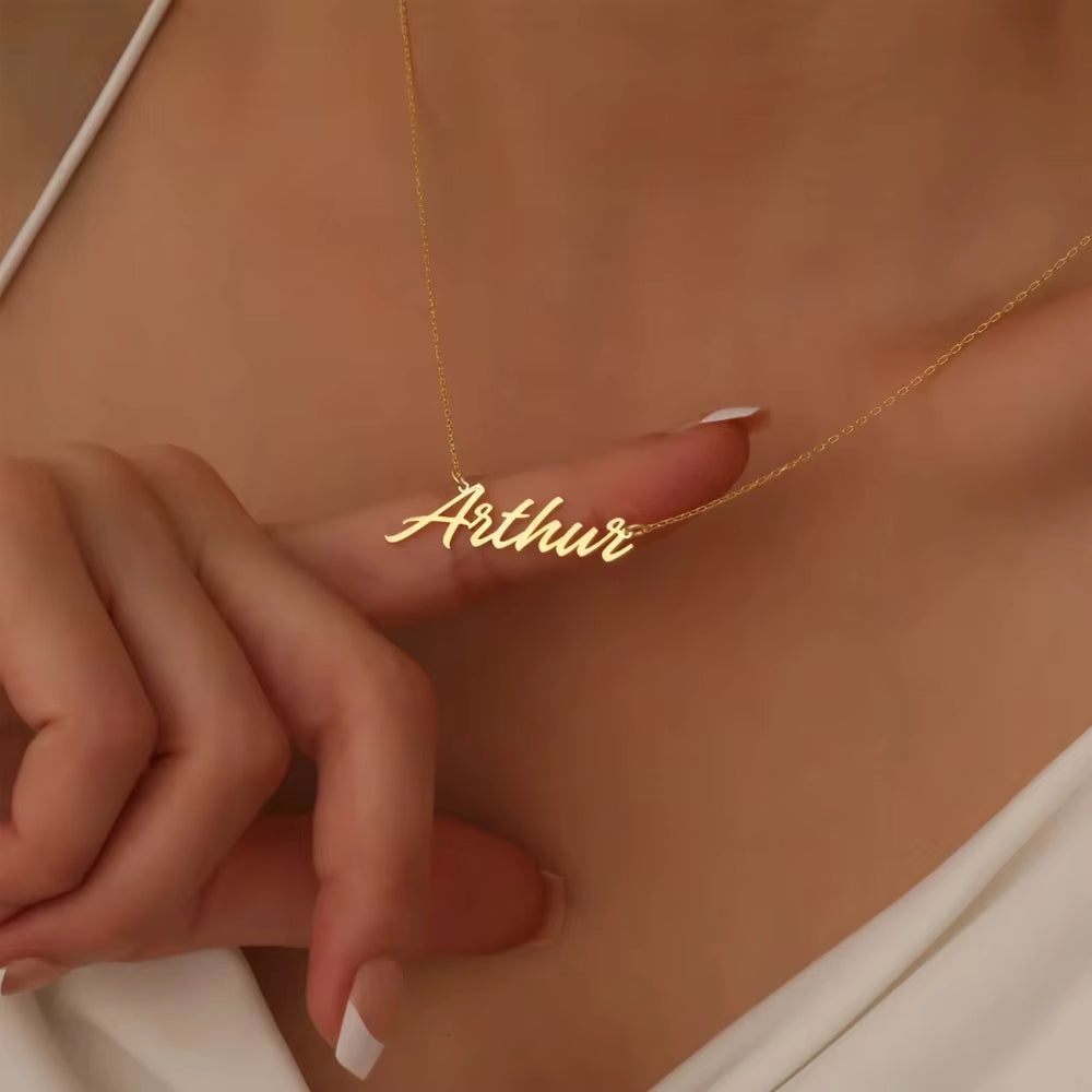 Close-up of gold chain with name pendant.