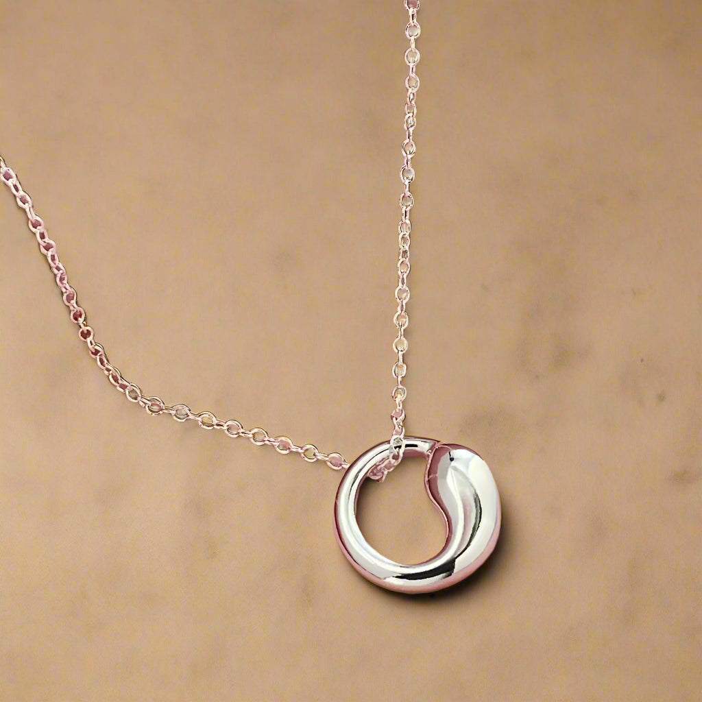 Close-up of silver loop necklace with lobster clasp.