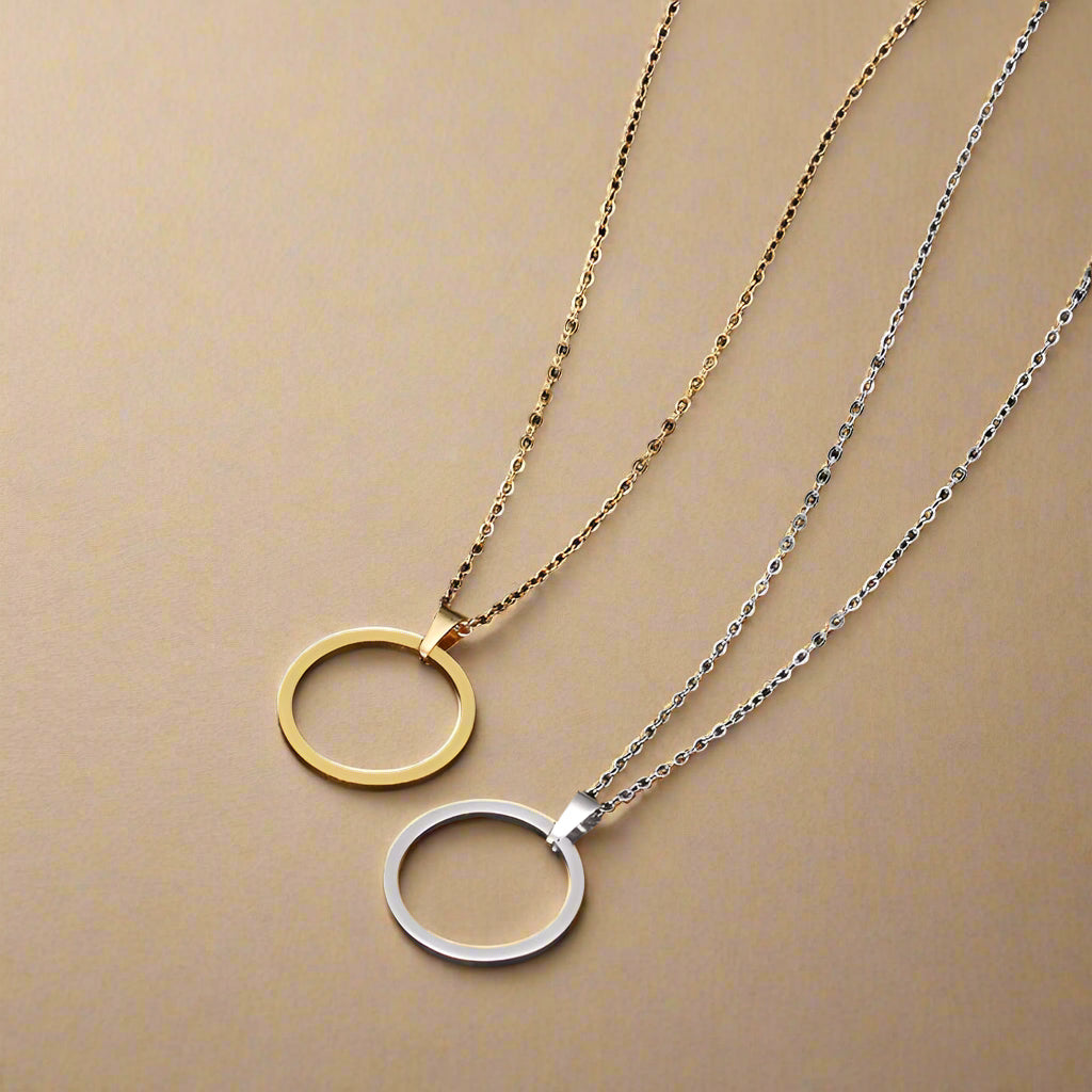 Gold stainless steel circle jewelry set on black background – necklace and stud earrings
