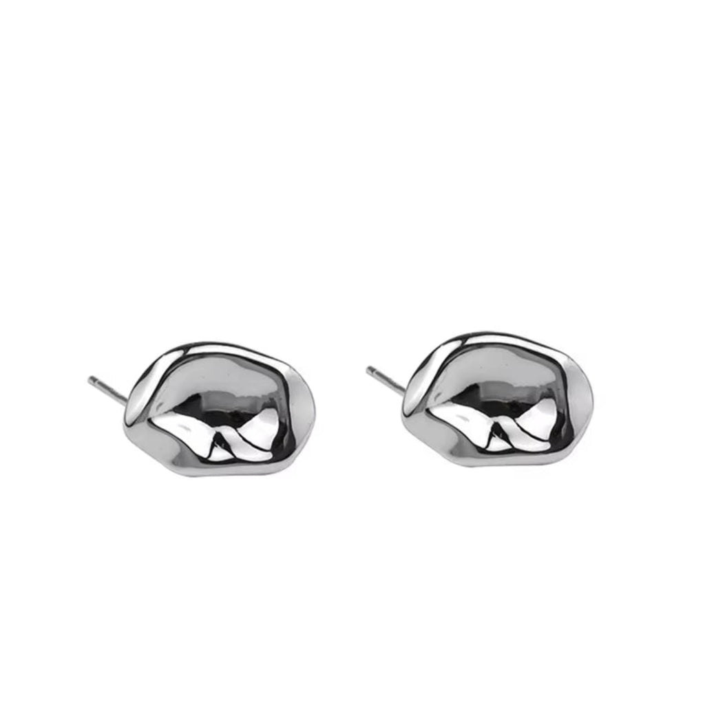 Close-up of molten-shaped earrings being held by hand for detail view
