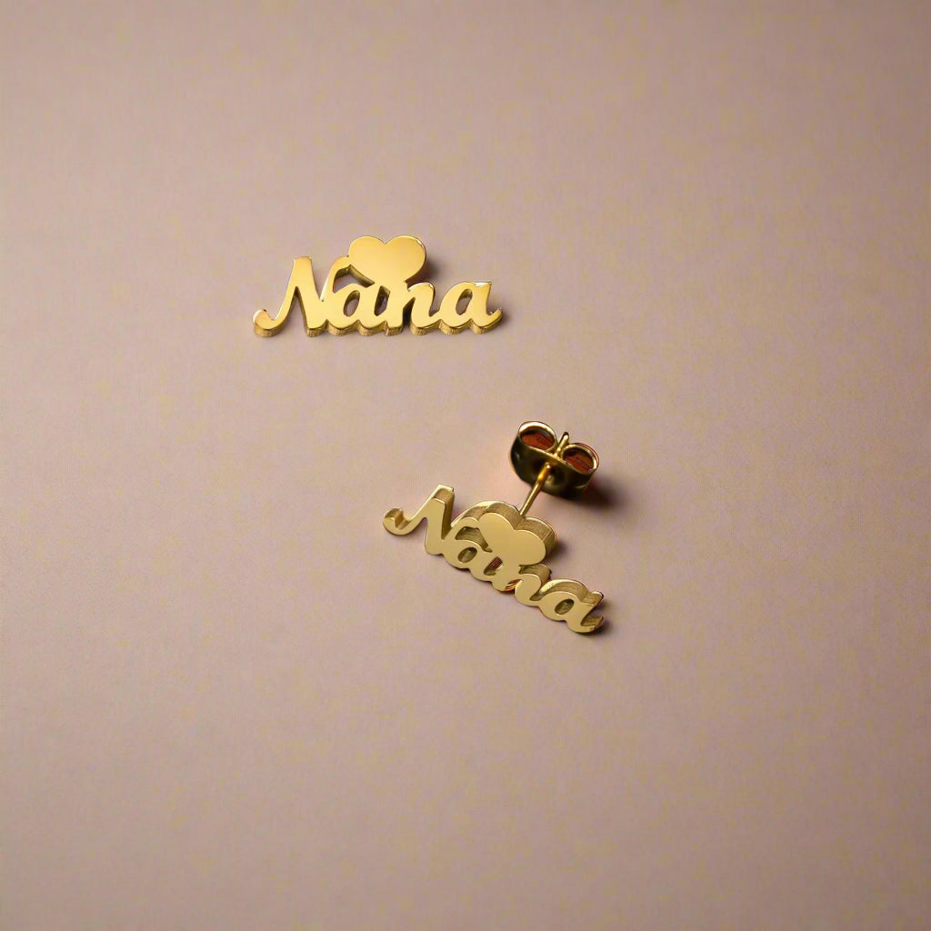 Close-up of personalized gold earrings with heart accents.