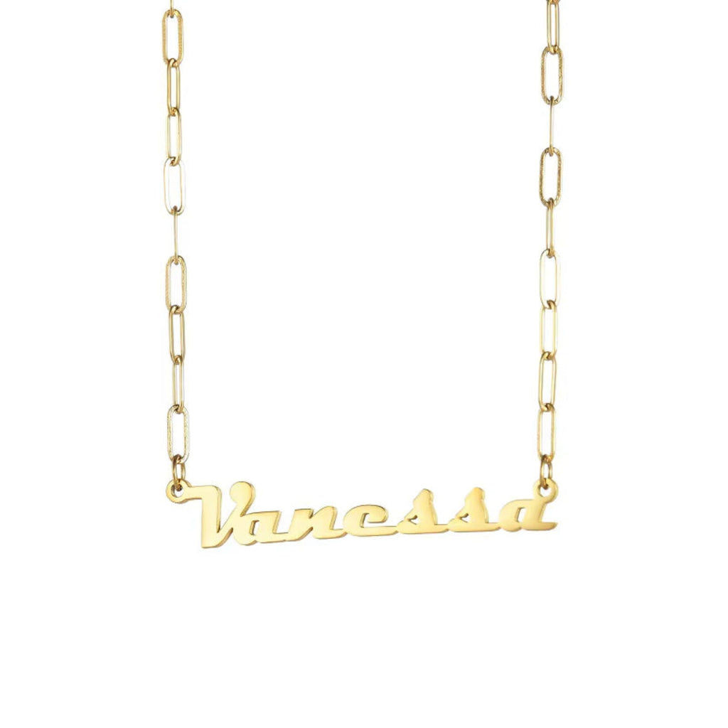  Close-up of gold name necklace on black surface