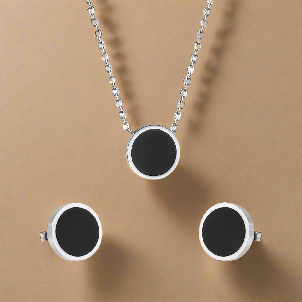 Close-up of black and gold geometric jewelry on soft silver fabric