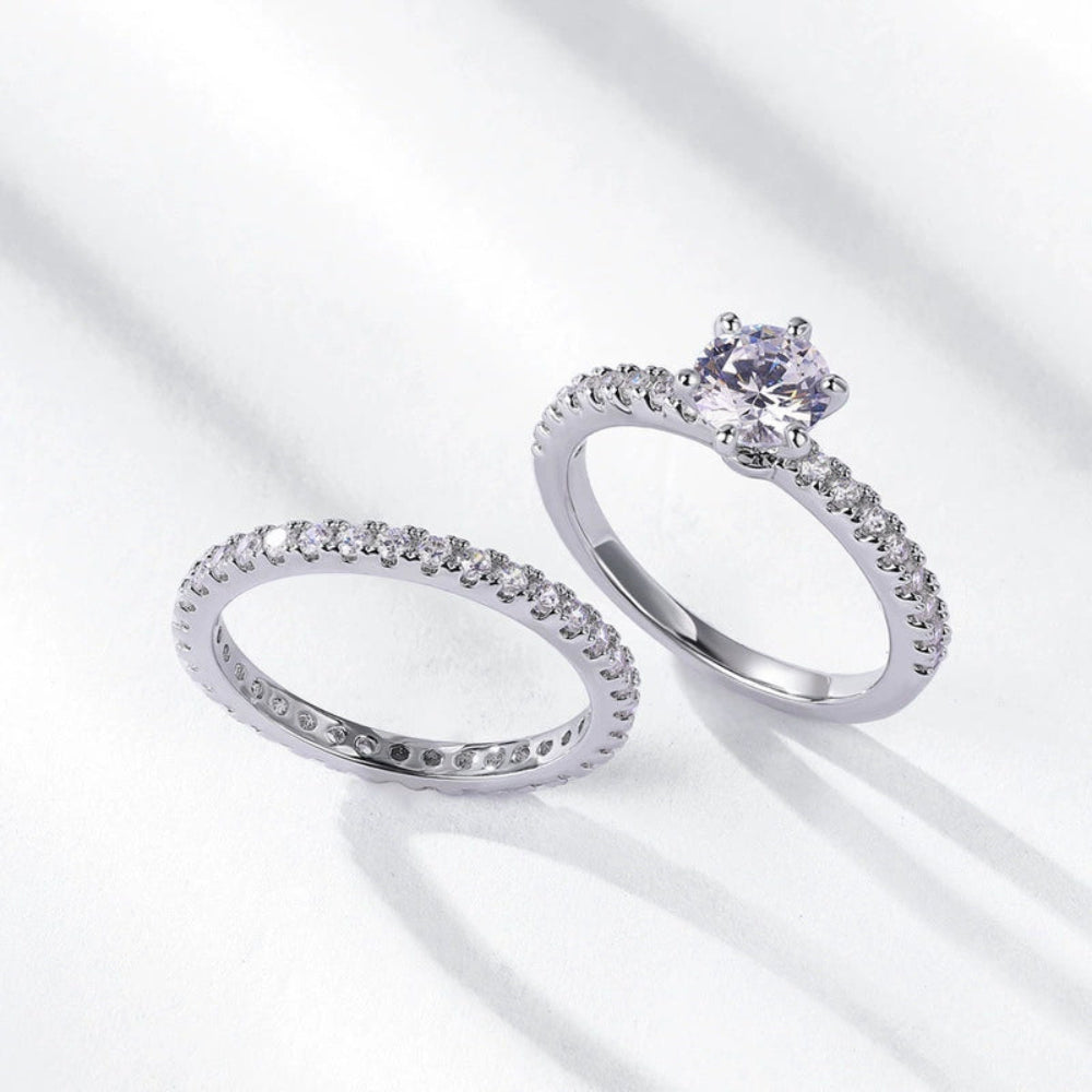 Elegant ring set with round center stone on a white background.