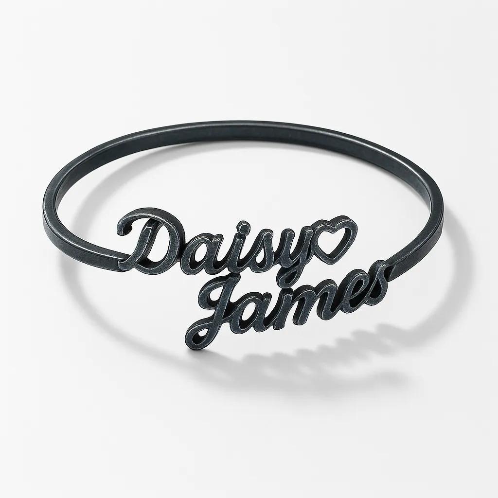 Black bracelet with 'Daisy James' engraving on a white background
