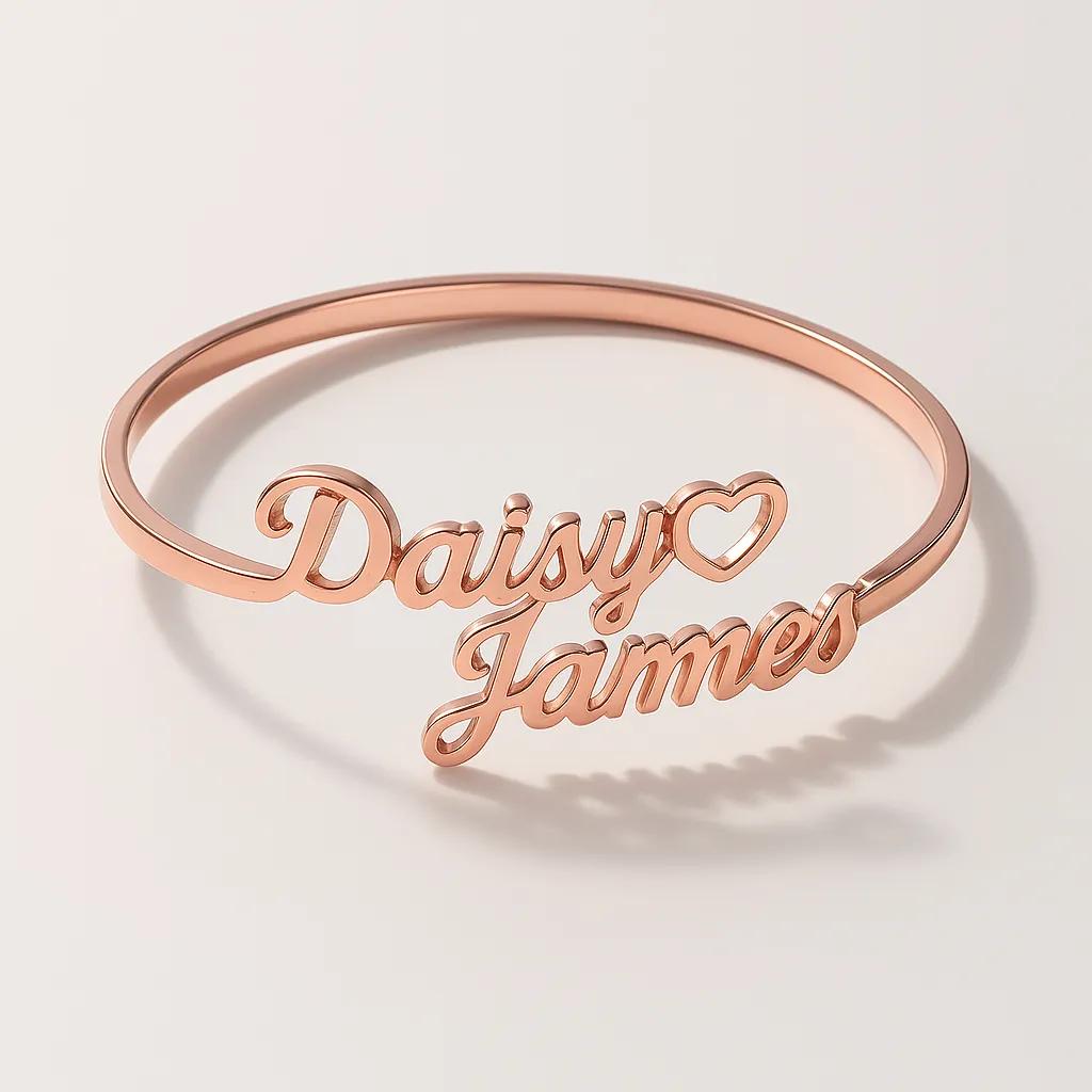 Rose gold bracelet with 'Daisy Loves James' engraving on a light background