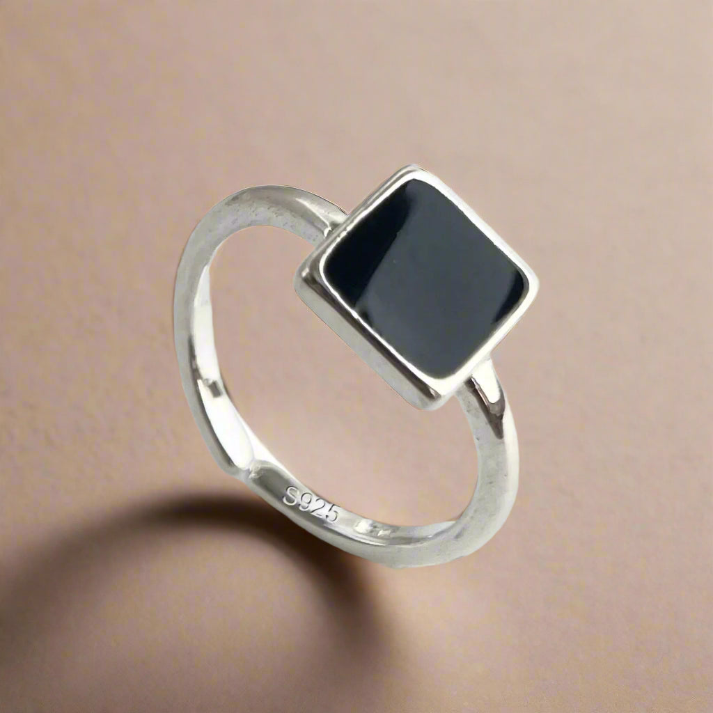 Adjustable black square silver ring worn on hand with casual outfit