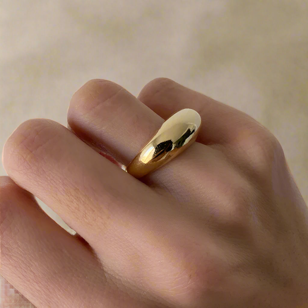 Close-up of a minimalist gold-plated ring, smooth finish