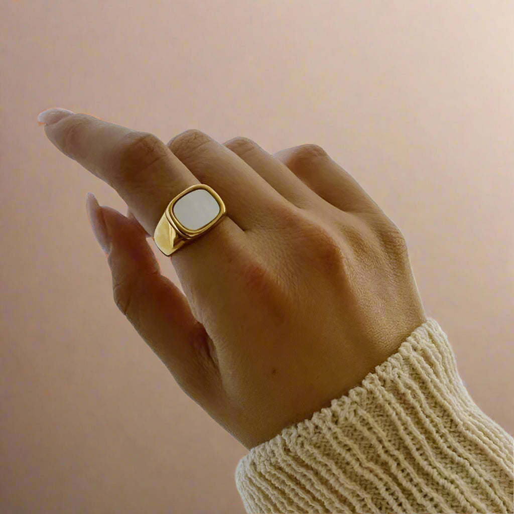 Close-up of minimalist gold ring with pearl detail. 