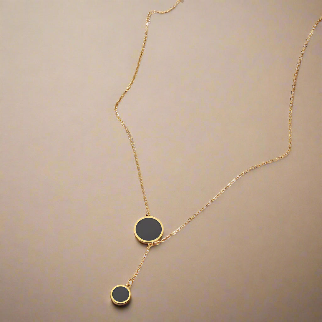 Minimalist black enamel circle pendant necklace in gold finish – flat lay