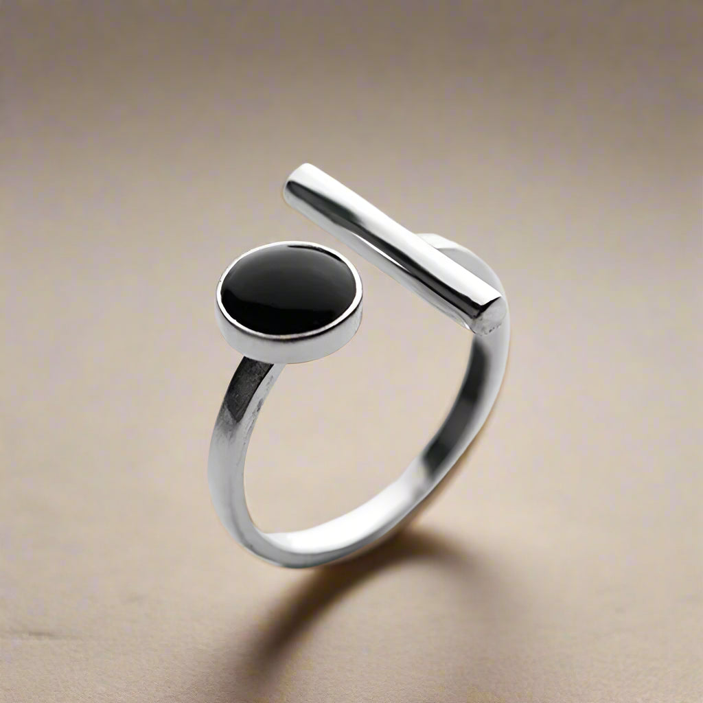 Fashionable silver-tone adjustable ring worn on model's hand with minimal manicure