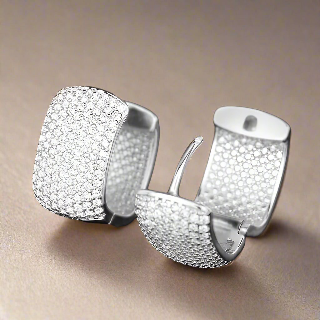 Silver U-shaped hoop earrings with cubic zirconia on black background