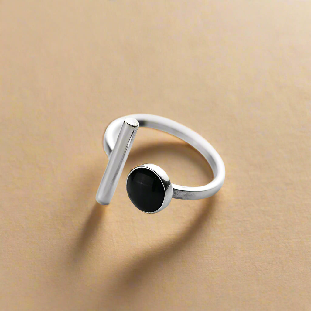 Fashionable silver-tone adjustable ring worn on model's hand with minimal manicure