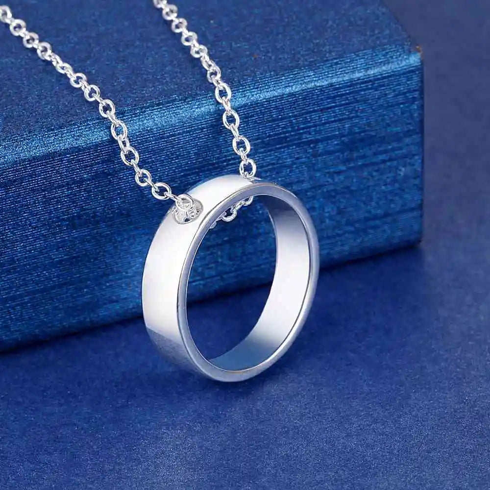 Sterling silver necklace with a circular pendant on a blue background.