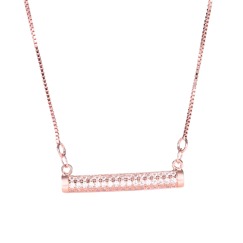 Rose gold necklace with a cylindrical pendant on a light background