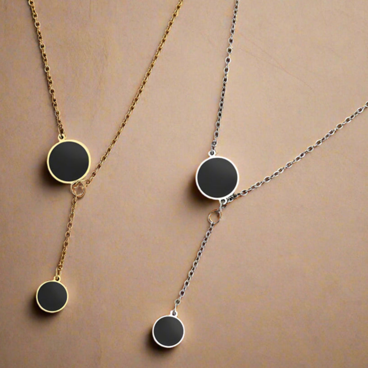 Silver Y-shaped necklace with double black enamel circles – close-up on model’s neck