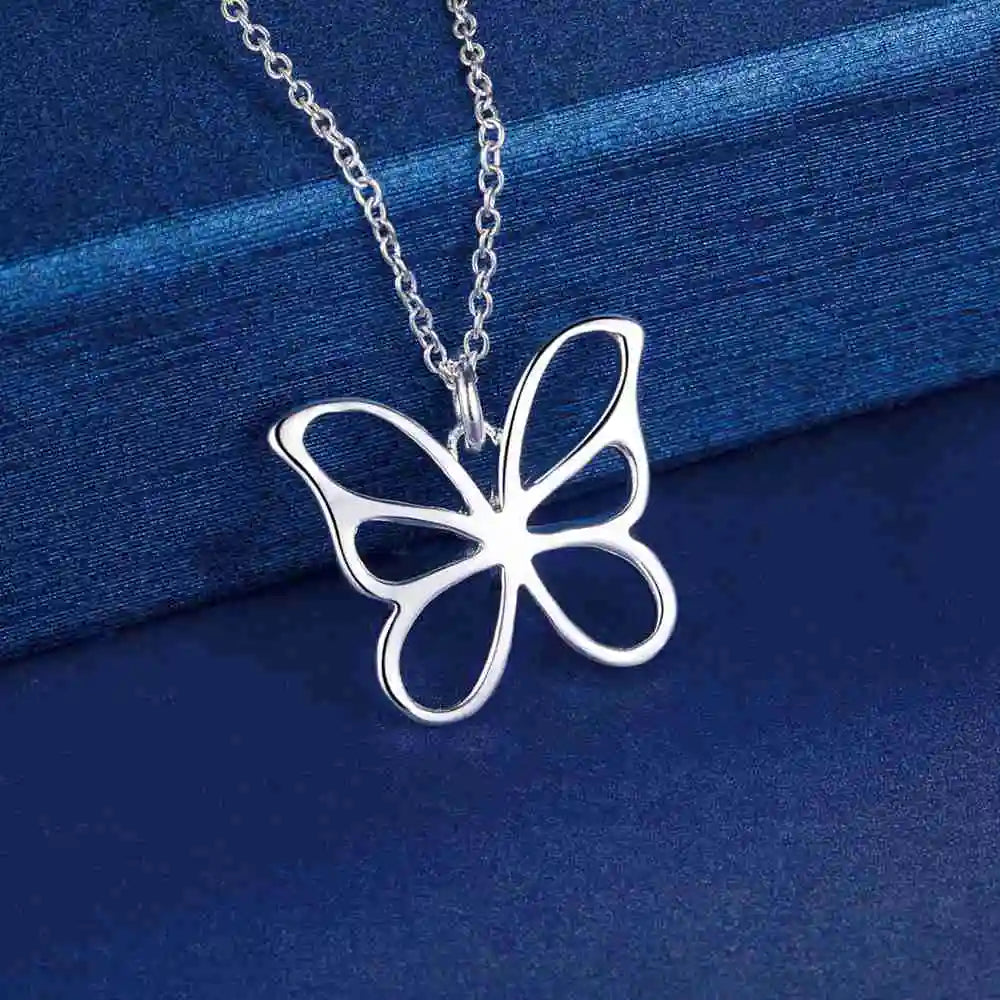  Silver butterfly pendant necklace on a blue fabric background.
