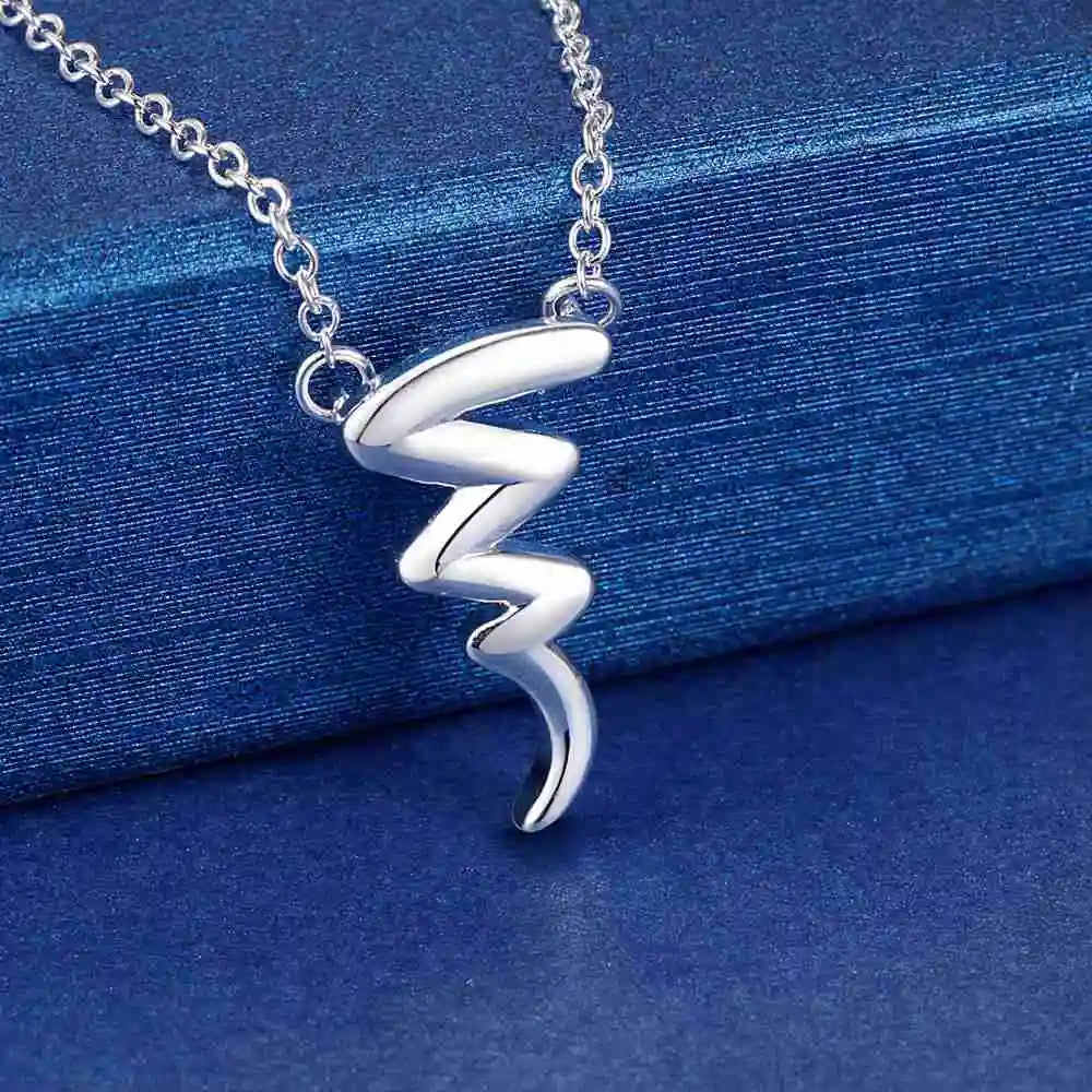 Sterling silver wave pendant necklace on a blue surface