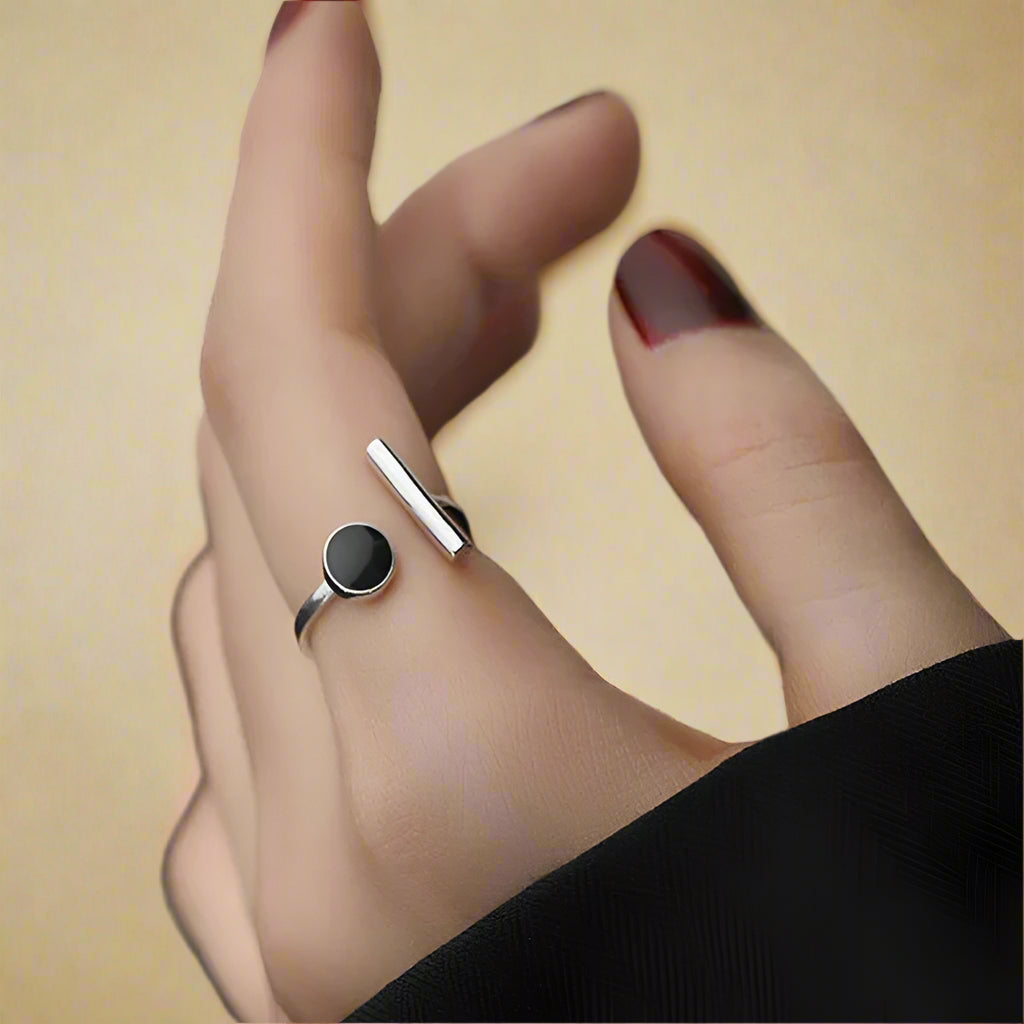 Modern open cuff ring with black resin and silver bar – close-up