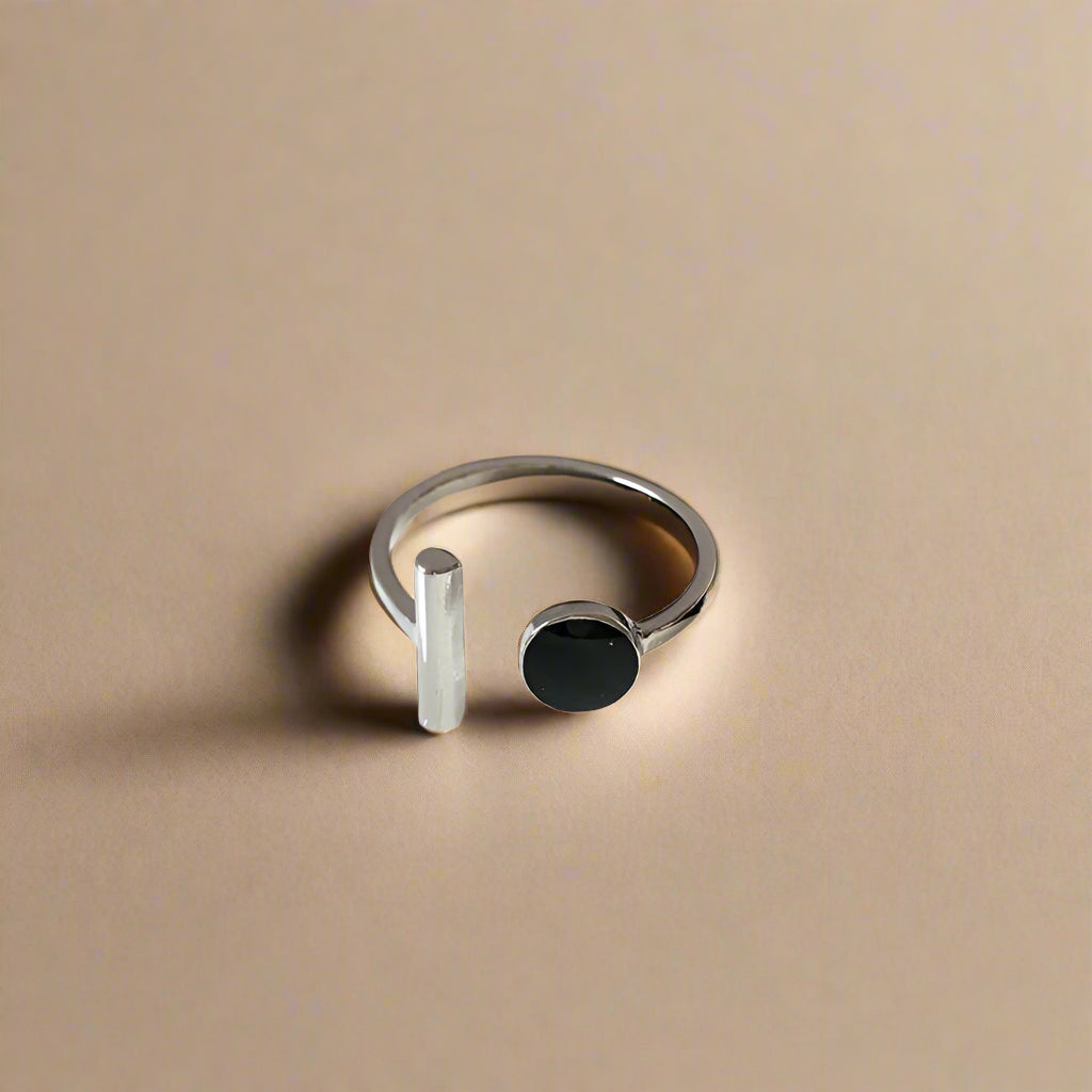 Fashionable silver-tone adjustable ring worn on model's hand with minimal manicure