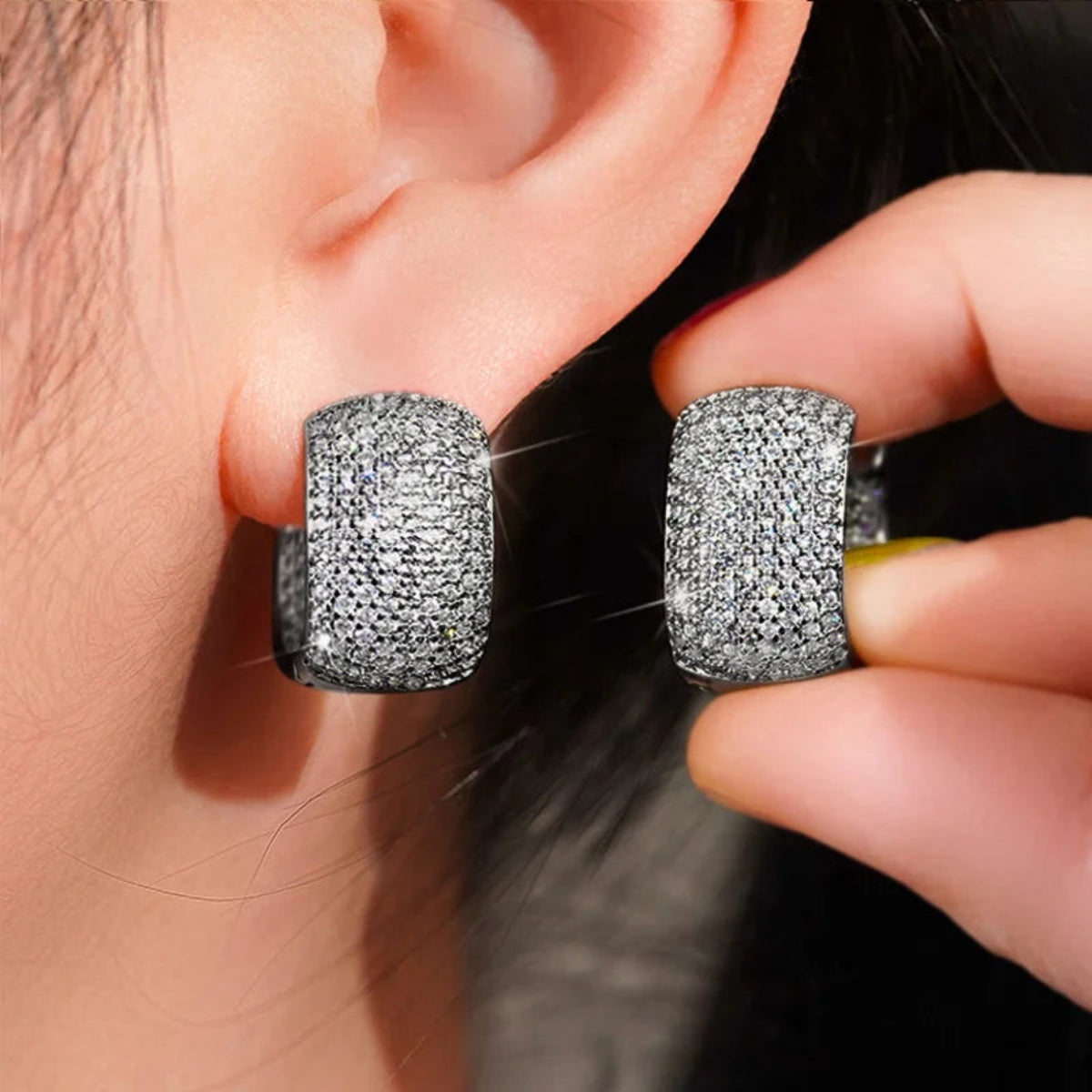 Model wearing wide pave cubic zirconia hoop earrings