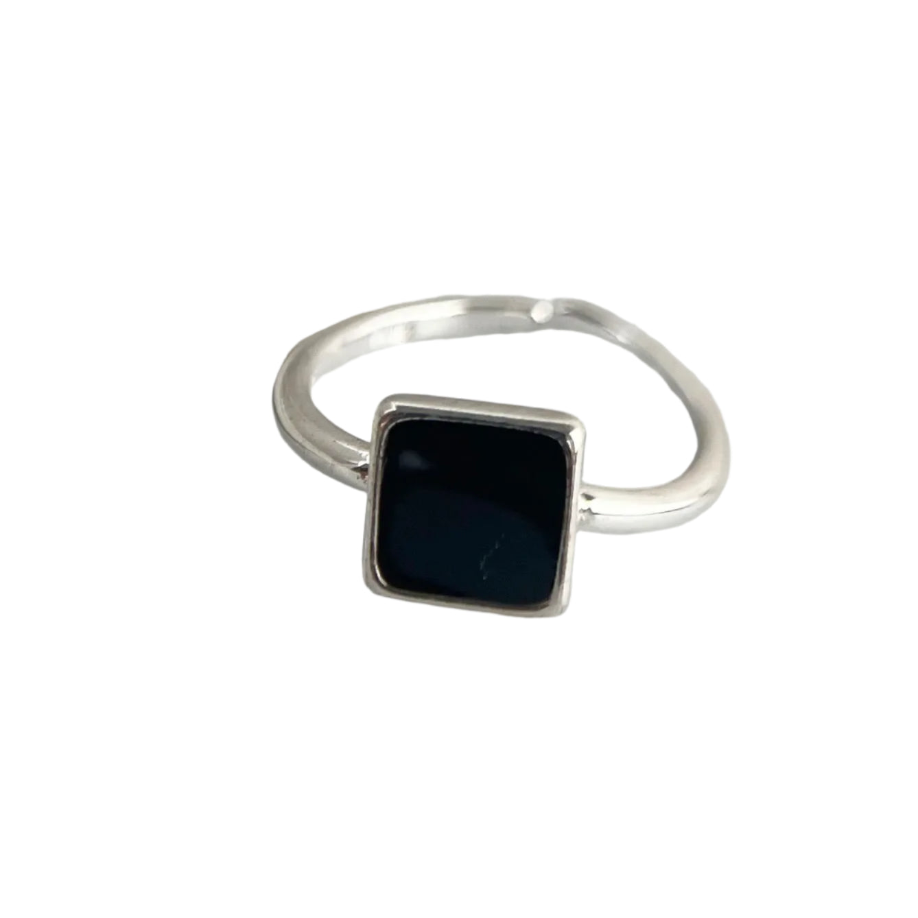Close-up of silver ring with black square stone on white background