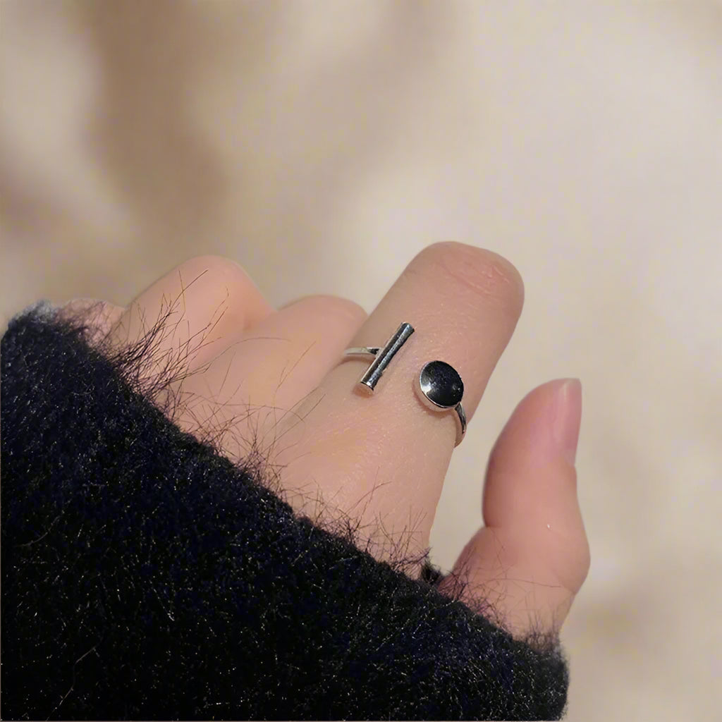 Modern open cuff ring with black resin and silver bar – close-up