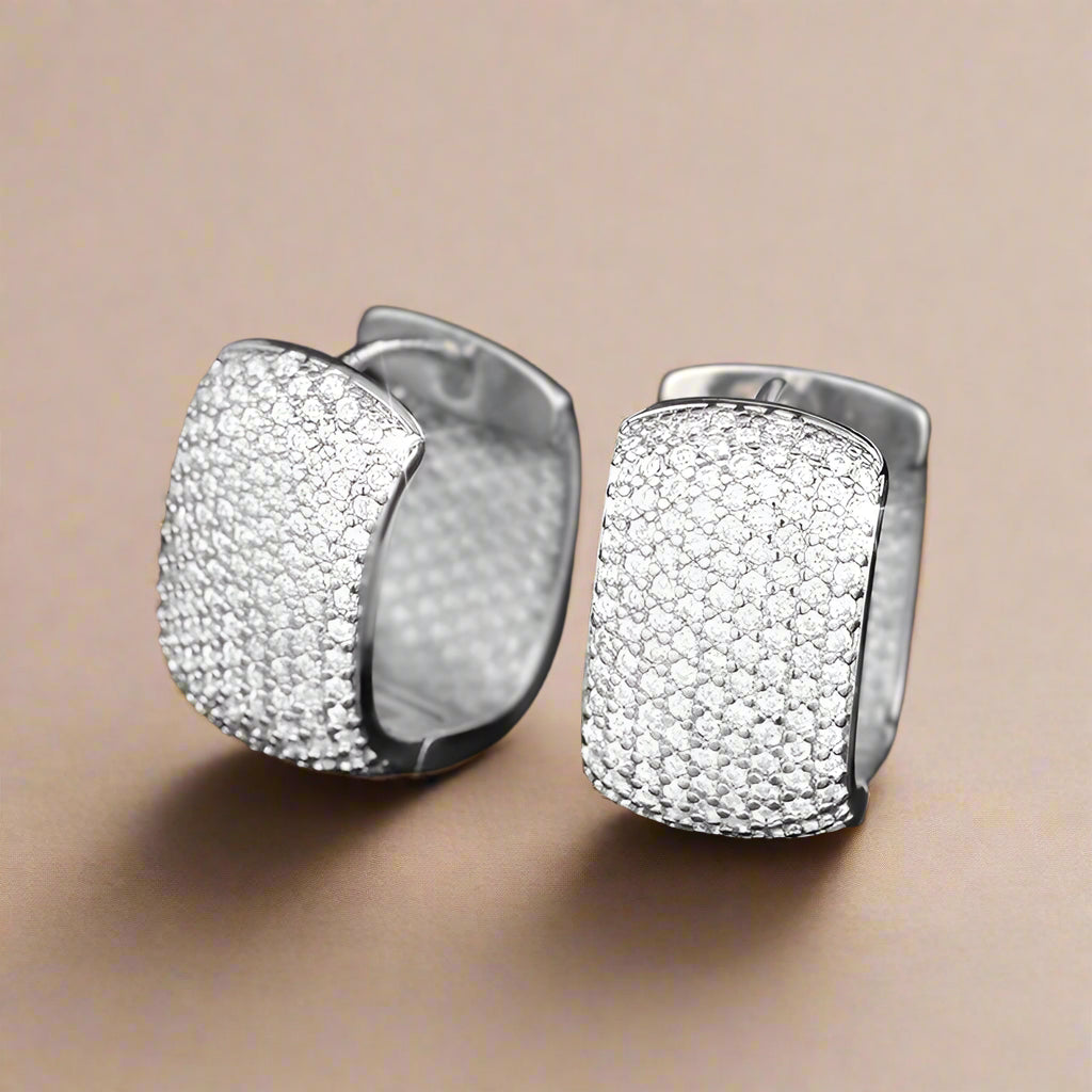 Silver U-shaped hoop earrings with cubic zirconia on black background