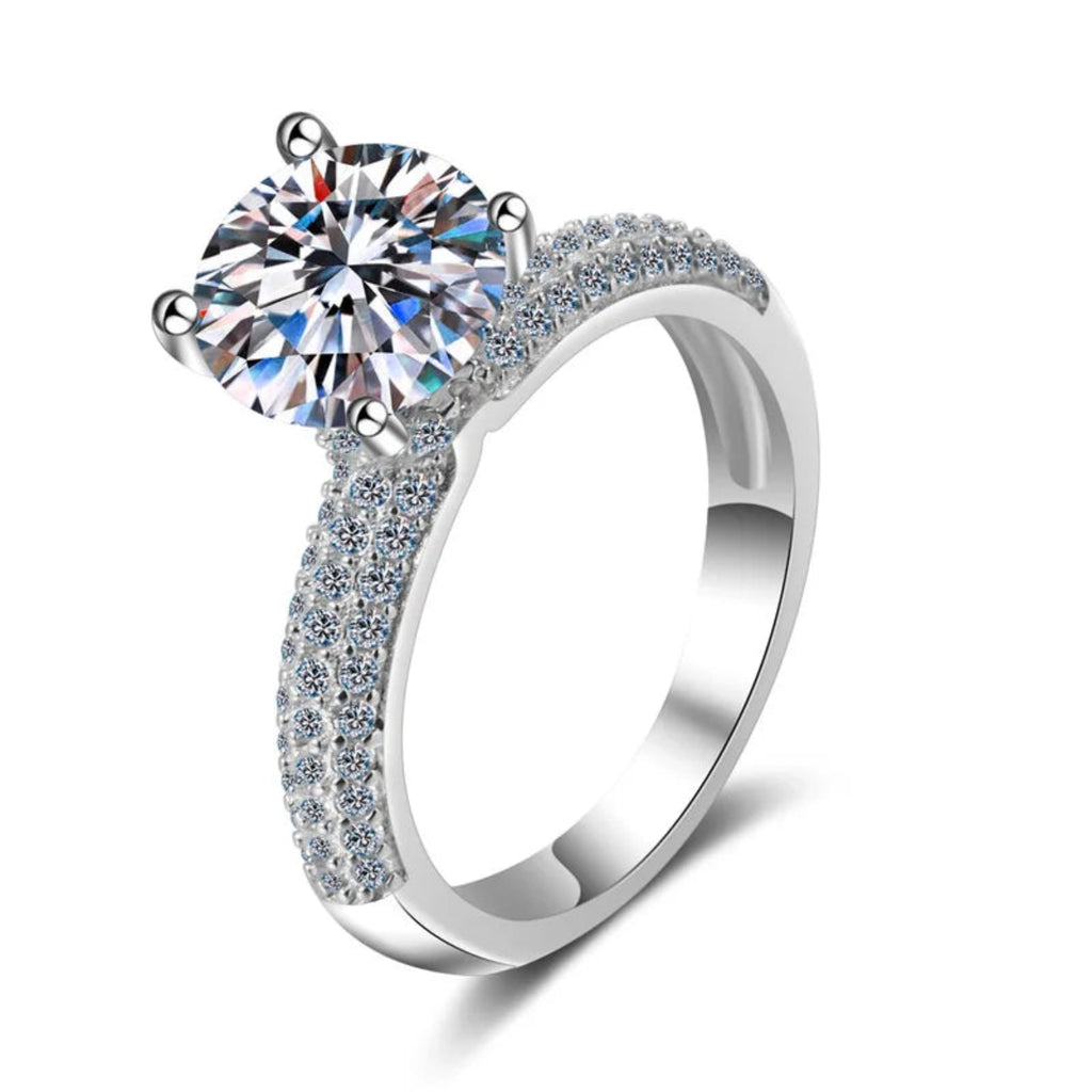 Elegant ring with moissanite centerpiece and pavé stones.