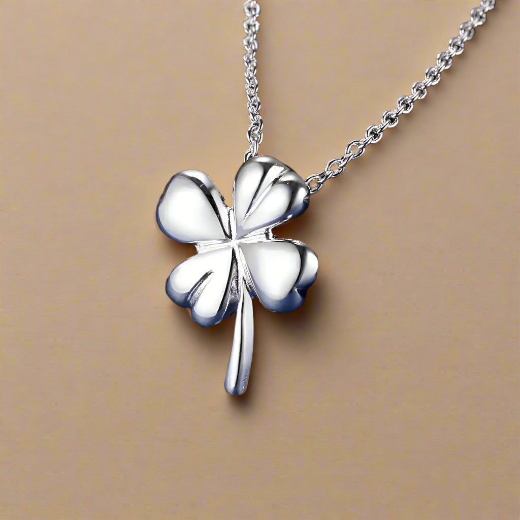 Sterling silver clover pendant necklace on blue background.